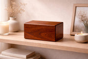 Wooden urn box on a shelf with candles and decor items